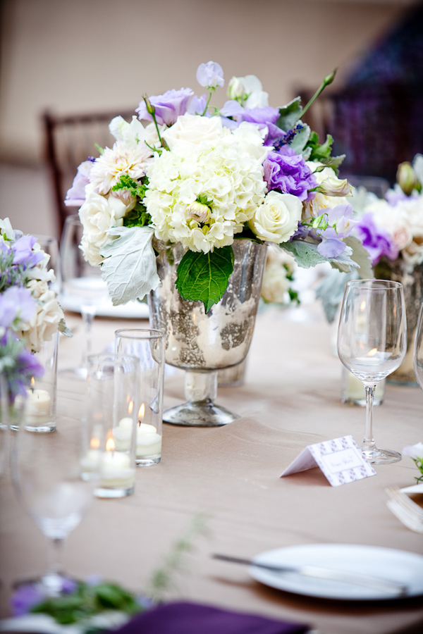 reception floral detail -a beautiful ivory, white, purple, light blue, and green centerpiece in an antique silver vase - photo by New Mexico based wedding photographers Twin Lens